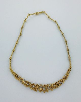 un collier en or orné de petites perles sur fond blanc