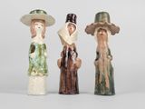 trois figurines en céramique représentant des femmes portant un chapeau et un foulard sur la tête
