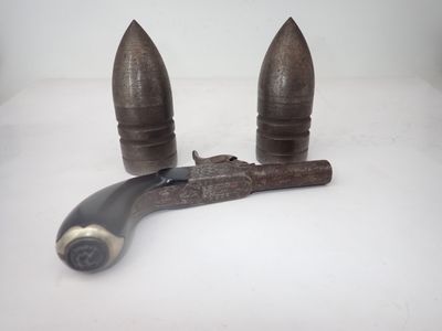 une pipe et un pistolet posés sur une surface blanche