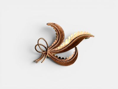 an image of a brooch with a gold leaf on it