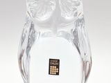 une figurine de chouette en verre posée sur une surface blanche