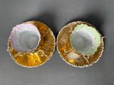 pair of gold and white dishes with flowers on them on a gray surface