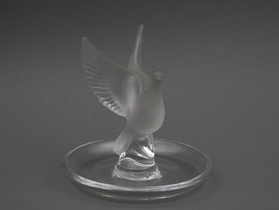 un oiseau en verre posé sur une assiette en verre