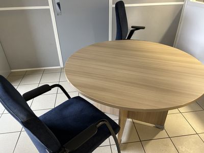 a table and chairs in a room with white tile flooring