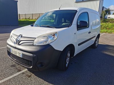 une camionnette blanche garée sur un parking près d'un immeuble