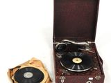 un vieux tourne-disque posé à côté d'une valise marron