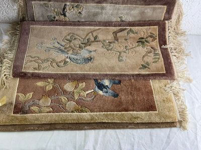 deux tapis ornés d'oiseaux, posés sur un lit