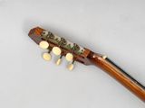 a close up of a guitar with a wooden neck on a white surface