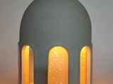 une lampe posée sur une table à côté d'un vase