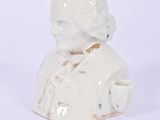 a small white figurine of a man with a hat on