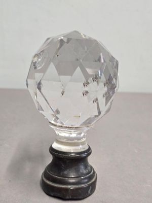 un bouton en verre posé sur une table