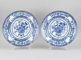 two blue and white plates with floral designs on them