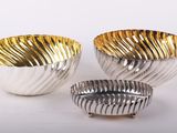 trois bols en argent et en or sur fond blanc
