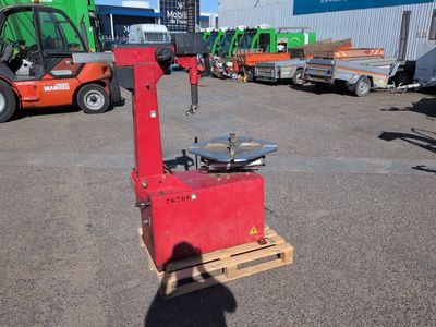 a red machine that is sitting in a parking lot