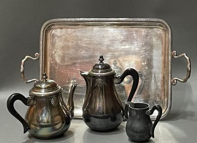 trois théières en argent et un plateau en argent posés sur une table