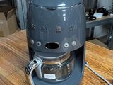 a coffee maker sitting on a wooden table in a kitchen