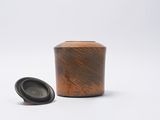 a small wooden container with a lid on a white surface