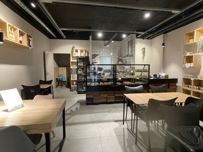des tables et des chaises dans une pièce équipée d'étagères fixées au mur