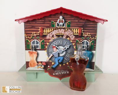 une horloge sur laquelle figure un homme, à côté d'un verre de bière