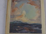 un vieux livre avec une image représentant l'océan et des nuages
