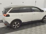 the rear end of a white suv parked in a garage