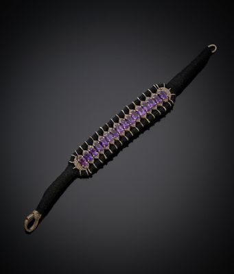 un gros plan d'un bracelet violet et noir sur fond noir