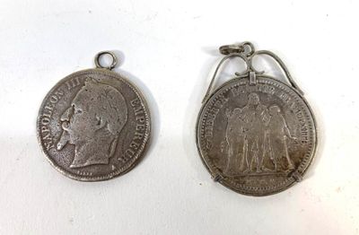 two silver coins are sitting next to each other on a white surface