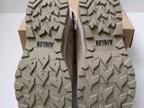 the soles of a pair of men ' s hiking shoes on a white surface