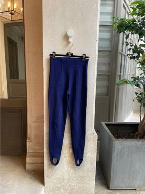 blue pants hanging on a wall next to a potted plant