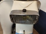 a white and blue motor scooter with a light on it