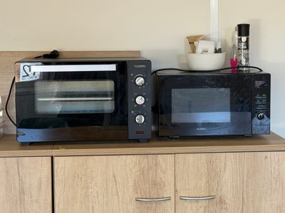 two microwaves that are sitting on top of a cabinet