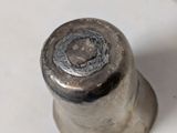 a small metal object on a white surface
