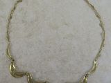 un gros plan d'un collier en or posé sur une surface en marbre