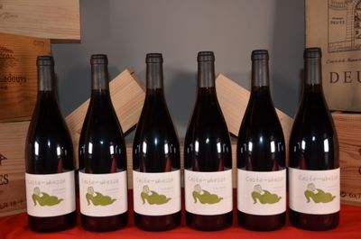 six bottles of red wine are lined up on a table