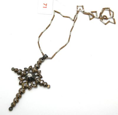 une photo d'un collier avec une croix suspendue à une chaîne