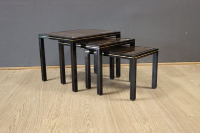 three black nesting tables sitting on top of a hard wood floor