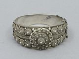 a close up of a silver bracelet on a white surface