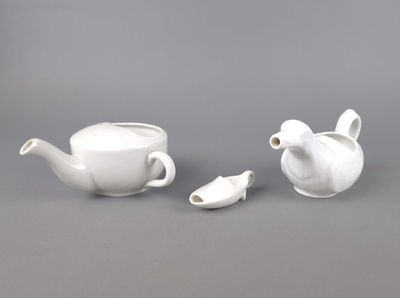 deux théières et une tasse à thé posées sur une table