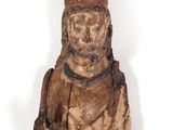 an old wooden statue of a man with a hat and a bag