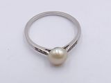 an image of a ring with a pearl on it on a white surface