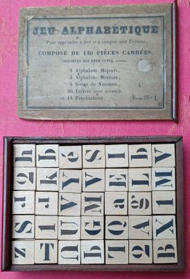un gros plan sur une boîte de blocs en bois sur lesquels figurent des lettres