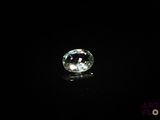 a close up of a green diamond on a black surface