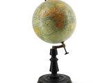 a small globe that is on a stand on a white surface