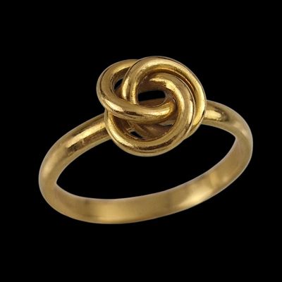 gros plan d'une bague en or sur fond noir