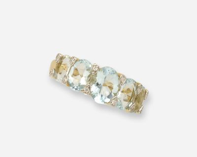 un gros plan d'une bague sertie de trois pierres sur fond blanc