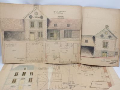 un livre ouvert sur lequel sont posés des dessins représentant une maison et des plans