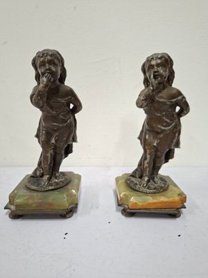 pair of bronze figurines of a boy and a girl on marble bases