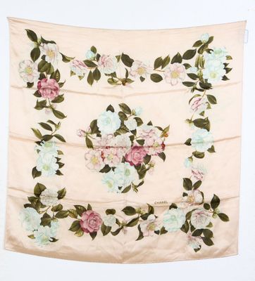 un foulard à motifs floraux blancs et roses accroché au mur