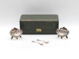 a pair of silver plated sheep figurines in a box