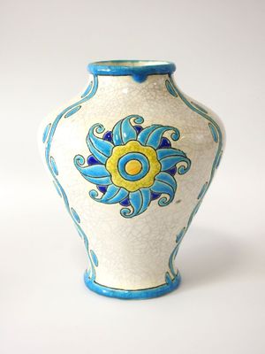 un vase blanc orné d'un motif bleu et jaune